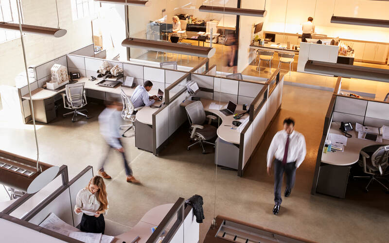 Busy open plan office with workers walking around - example of commercial fit out.